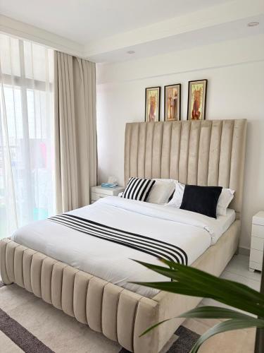 a bedroom with a large bed with a large headboard at Skyline Westlands with Gym in Nairobi