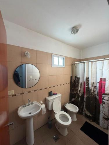 a bathroom with a sink and a toilet and a mirror at Departamento en Ezeiza - SA in La Unión