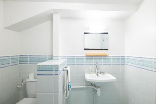 a white bathroom with a sink and a toilet at Gîte Zelai Begi in Aldudes