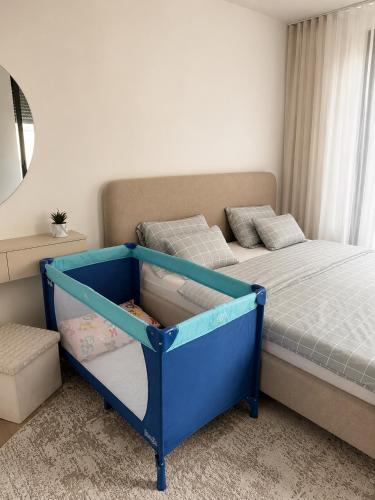 a bedroom with a blue bed with a drawer at Una Lux Apartment in Sombor