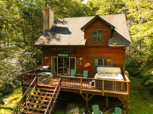 a house with a large deck with a porch at Waterfall Cottage in Boone
