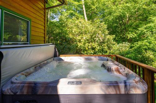 a hot tub on the deck of a house at Waterfall Cottage in Boone