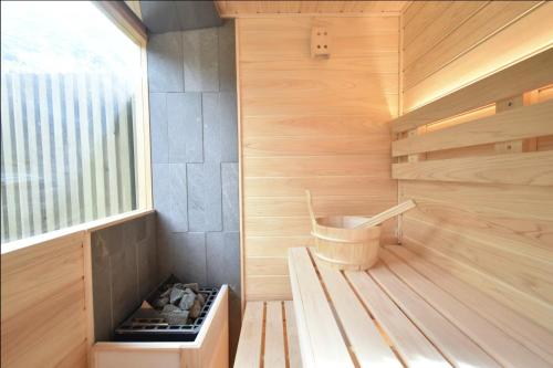 an inside of a sauna with a bench and a window at 熱海の貸切温泉宿 kintsugi プライベートサウナ BBQ in Atami