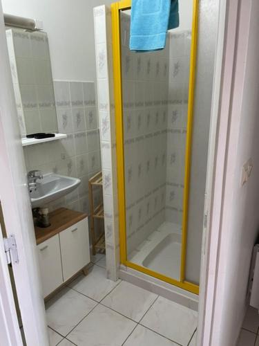 a shower with a yellow frame in a bathroom at La dame du bois in Gramat