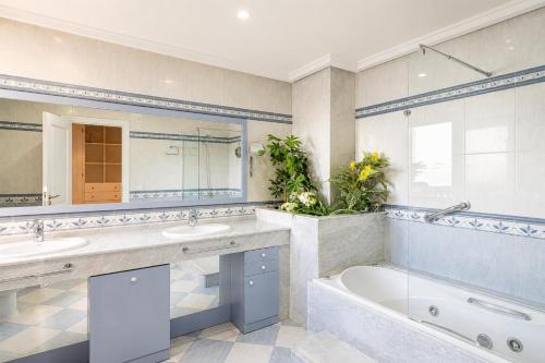 a bathroom with two sinks and a bath tub and a tubermott at Villa Casa Faro in Alcanada