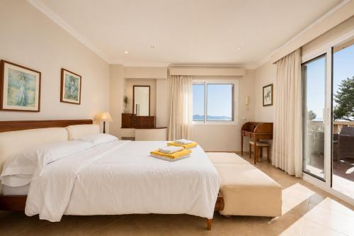 a bedroom with a large white bed and a piano at Villa Casa Faro in Alcanada