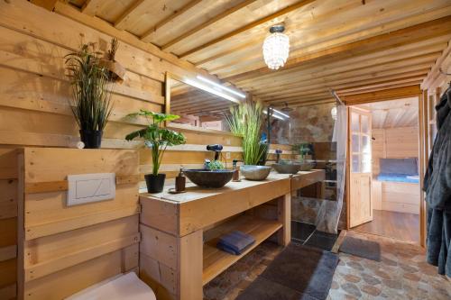a log cabin bathroom with a sink and potted plants at Beskydy Areal in Prostřední Bečva