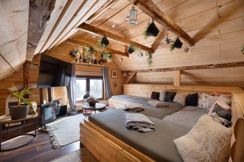 a bedroom with a large bed in a log cabin at Beskydy Areal in Prostřední Bečva