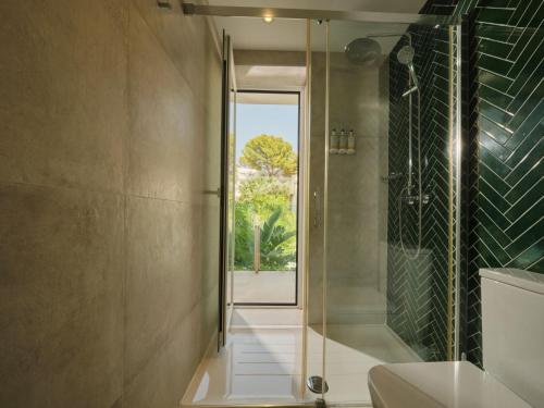 a bathroom with a shower and a glass door at BQ Paguera Boutique Hotel - Adults Only in Paguera