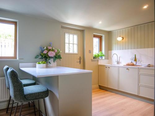 a kitchen with a counter and two stools in it at Cottage on the Lane Dingle in Dingle