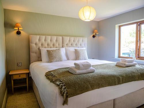 a bedroom with a large bed with two towels on it at Cottage on the Lane Dingle in Dingle