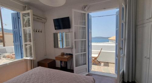 a bedroom with a bed and a view of the ocean at Panoramic View apartment in Poros