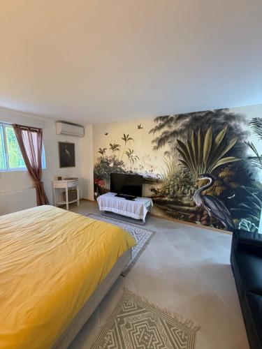 a bedroom with a yellow bed and a painting on the wall at Le Refuge du Saule in Saint-Aubin-de-Locquenay