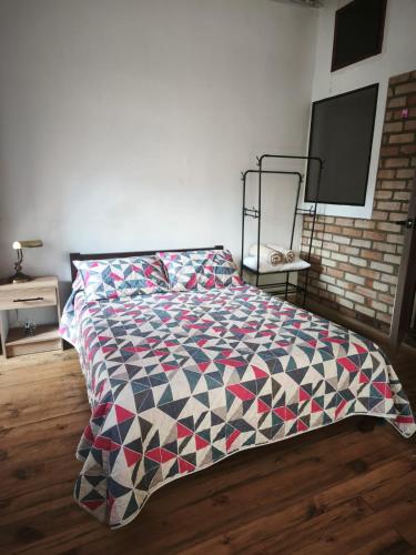 a bedroom with a bed with a quilt on it at Suite Central Campestre - Casa Matula in Popayan