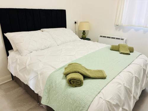 a large white bed with a towel on it at Cozy Grays Apartment in Grays Thurrock