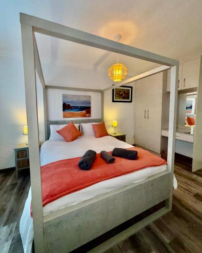 a bedroom with a bed with two pairs of shoes on it at Seashell Flat in Mossel Bay