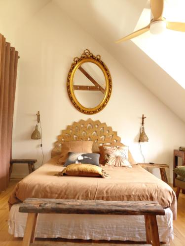 a bedroom with a large bed and a mirror at Le Banellou in Quimper