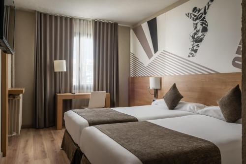 ein Hotelzimmer mit zwei Betten und einem Schreibtisch in der Unterkunft Estival Sporting in Pas de la Casa