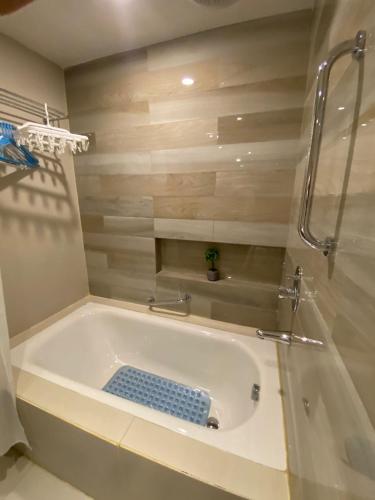 a bath tub with a blue mat in a bathroom at RKJ condotel 2BR in Cupang