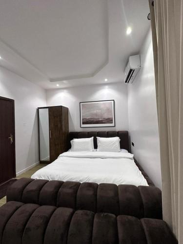 a bedroom with a large white bed with a couch at Raya in Lagos