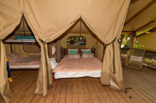a bedroom with a bed in a tent at Camping Hôtel Maui in Tournon-sur-Rhône