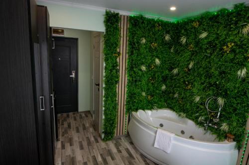 a bathroom with a green wall with a bath tub at Elma Nest in Drobeta-Turnu Severin