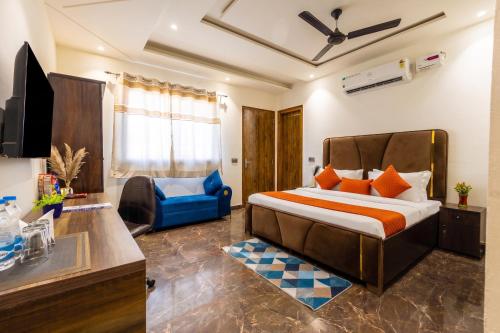 ein Schlafzimmer mit einem Bett und einem blauen Stuhl in der Unterkunft Hotel BNB Stays Near Golf Course Road in Gurgaon