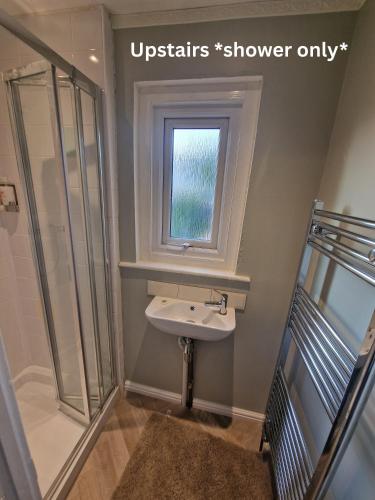 a bathroom with a sink and a window at Entire Charming Three Bedroom Seaside House With Garden - Close to Town & Beach, Ideal for Groups, Families in Sheringham