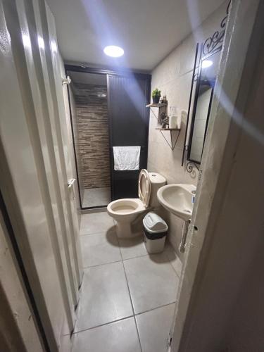 a small bathroom with a toilet and a sink at Apartamento amoblado Chinchiná in Chinchiná