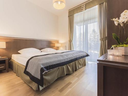 コウォブジェクにあるVacationClub - Diune Apartment 24のベッドと大きな窓が備わるホテルルームです。