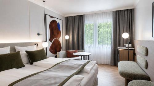 a hotel room with a bed and a chair at Crowne Plaza Berlin City Centre Ku'damm by IHG in Berlin