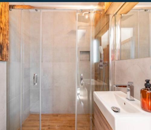 a bathroom with a shower and a white sink at Apartament Glamour II Kleszczów in Łękińsko
