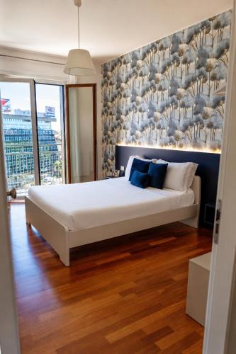 a bedroom with a large white bed with blue pillows at B&B Best Hostel Milano in Milan