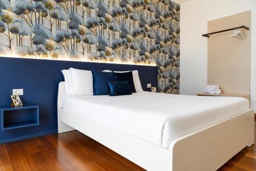 a bedroom with a white bed with a blue wall at B&B Best Hostel Milano in Milan