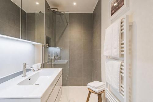a white bathroom with a sink and a shower at The View at Shoreline by Bloom Stays in Folkestone