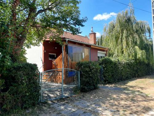 a house with a fence in front of it at Rika Vendégház in Pécsvárad