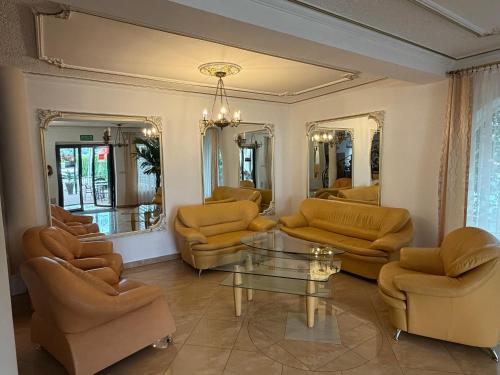 a living room with couches and a table and mirrors at Hotel Mimoza in Libusza