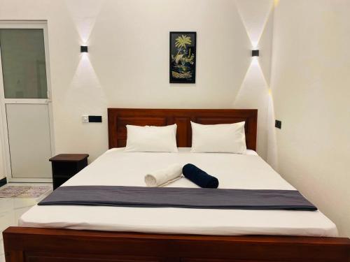 a bedroom with a large bed with white sheets at The Royal Ember in Arugam Bay