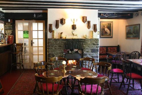 a dining room with tables and chairs and a fireplace at Staghunters Inn Hotel in Countisbury
