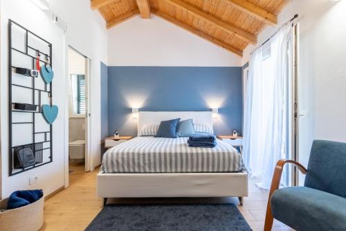 a bedroom with a bed and a blue wall at B&B I Menhir "nel Bosco" - Affittacamere in Lerici
