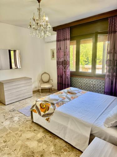 a bedroom with a large bed and a chandelier at Abir's Apartments 2 in Marghera