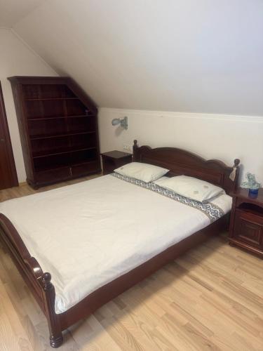 a bedroom with a large bed with a wooden headboard at Чарунки днів in Mukacheve