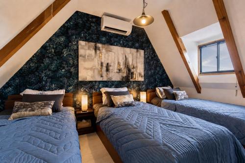 a attic bedroom with two beds and a wall at 愛犬と泊まれる一棟貸しviilaはBBQグリル無料利用可能サーフィンや釣りの拠点として in Kashima