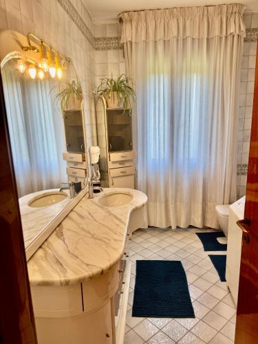 a bathroom with two sinks and a large mirror at Abir's Apartments 2 in Marghera