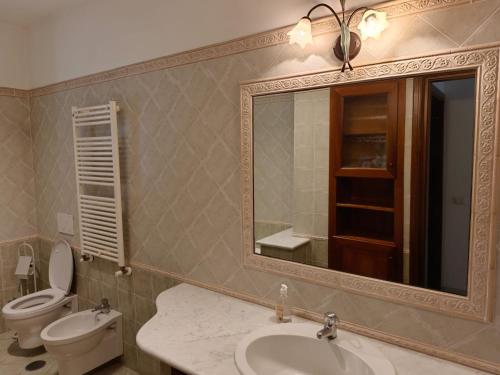 ein Badezimmer mit Waschbecken, Toilette und Spiegel in der Unterkunft Dolce Onda in Bolsena