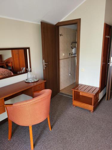 a hotel room with a desk and a bed and a bathroom at Vila Florena Garden in Palanga