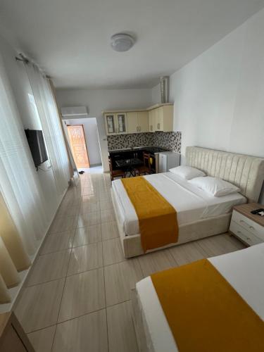 a hotel room with two beds and a kitchen at Aer Rooms Peshkopi in Peshkopi