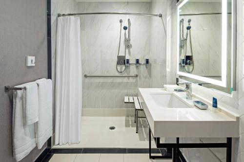 a white bathroom with a sink and a shower at Four Points by Sheraton Manhattan Midtown West in New York