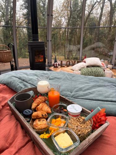 a tray of food sitting on top of a bed at A la bulle étoile 82 in Saint-Antonin