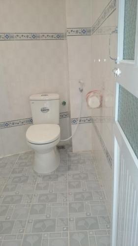 a bathroom with a white toilet and a shower at Hoang Ngoc Hotel in Dồng Văn